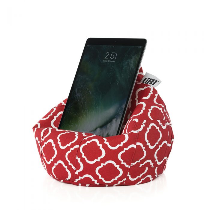 A tablet rests on the iCrib iPad bean bag tablet holder cushion. It is red with a white geometric print