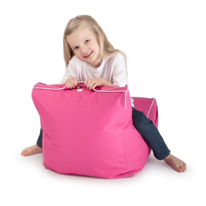 Kid sits on child size pink coastal lounge bean bag holding onto the handle