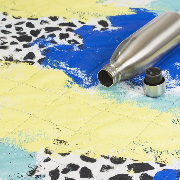 Close up of the tier yellow, green, blue and white print showing the quilting and spill resistant surface