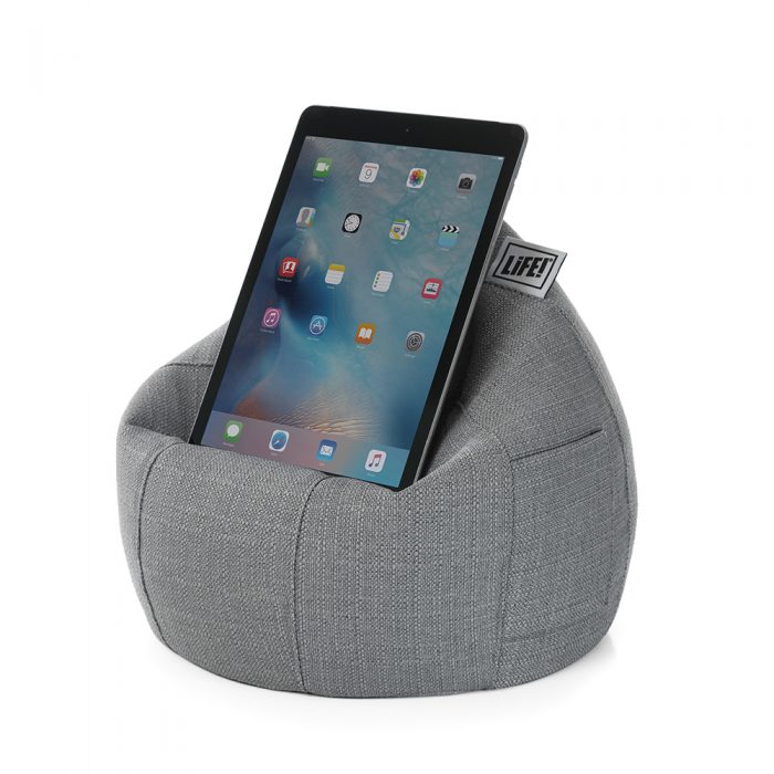 A tablet sits on a grey linen look iCrib iPad holder stand cushion bean bag. The storage pocket is visible