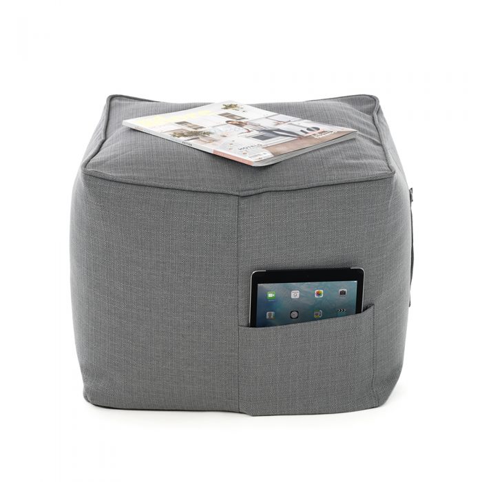 Grey linen look ottoman with a magazine on top of it and an iPad or tablet in the storage pocket