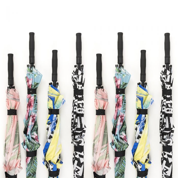 A line of 8 umbrellas in four prints with handles at varying heights