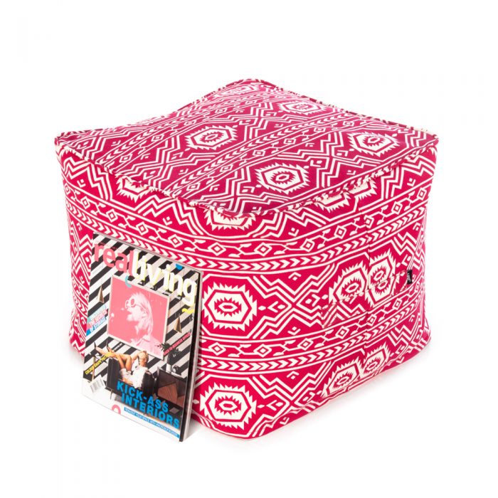Magazine rests against the red ottoman with white geometric Aztec tribal print