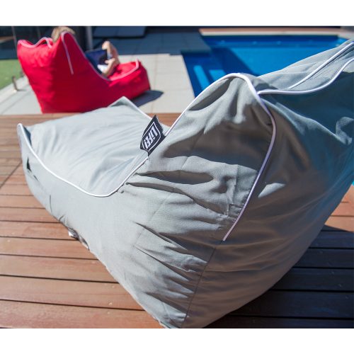 Grey coastal lounge bean bag and red coastal lounge bean back on decking beside a blue pool