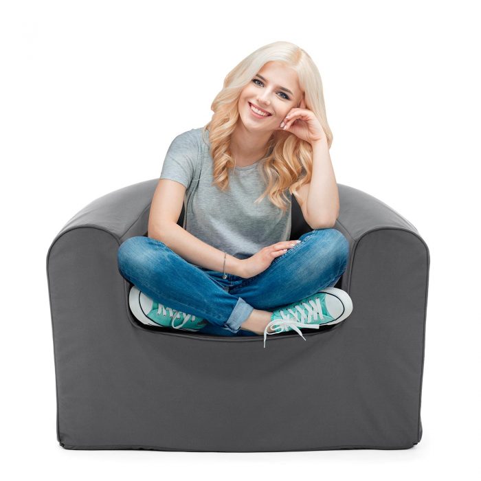 Women sits in a castle rock grey pop lounge foam armchair