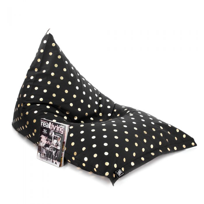 Oblique view of the black gold coin print sunnyboy shaped bean bag with a magazine resting against it