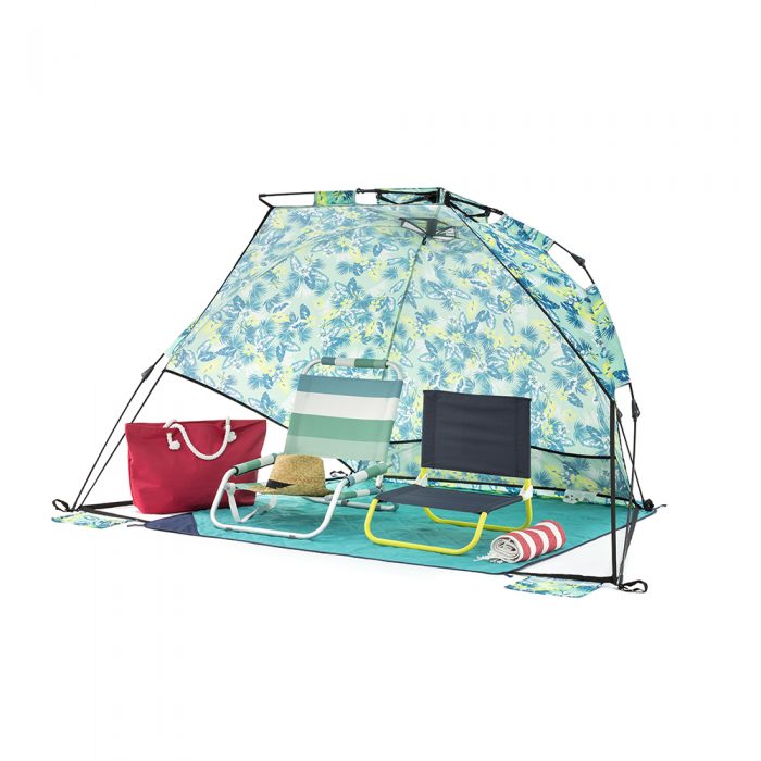 The tropical green adventure sun shelter for the beach, camping and picnics. Shown with two camp chairs inside on a picnic rug.