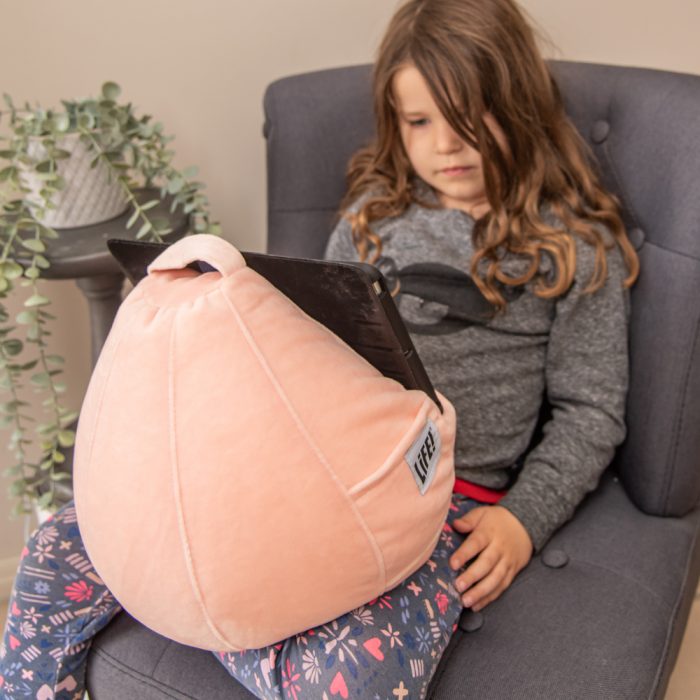 orange pink colored sherbet velvet iCrib bean bag table holder in use with a small girl using an ipad